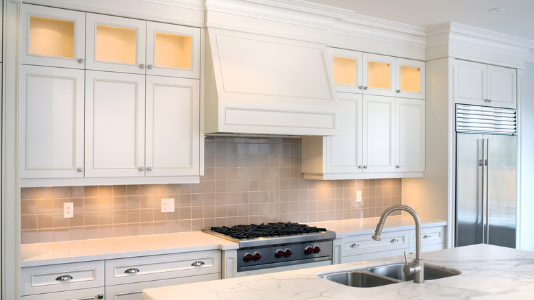 White kitchen with lights shining from below the cabinets