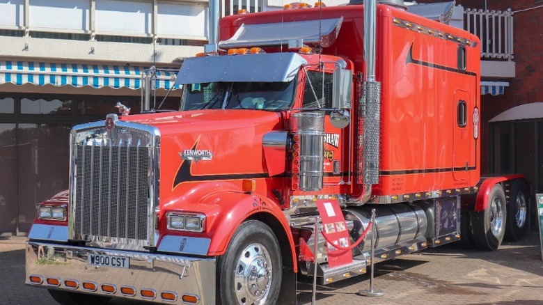 Red Kenworth W900L on display in front of a building