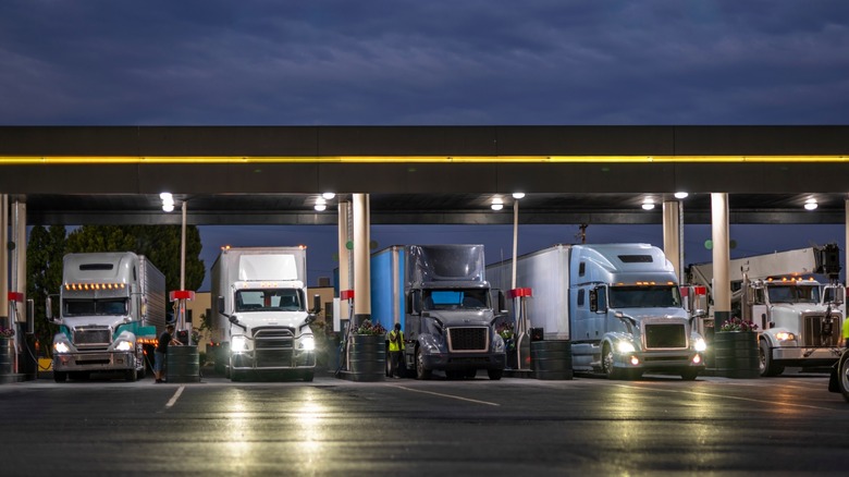 semi trucks lined up at gasoline station