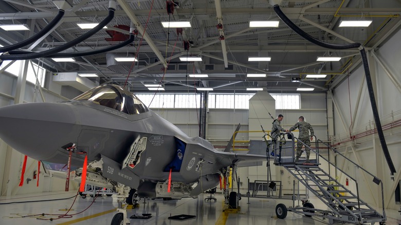 Maintenance tecs working on an F-35 inside of a hangar in 2016
