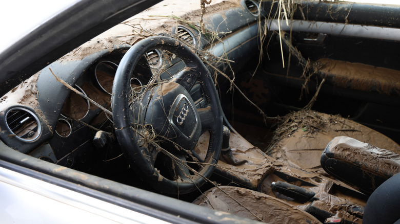 An Audi damaged by water following a storm with the interior caked in mud