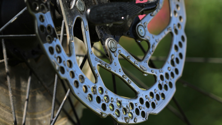 Close up shot of a Shimano rear wheel break disc with water droplets on it.