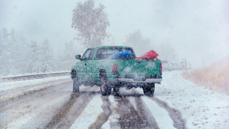 A pickup truck sliding on a snow covered road in winter.