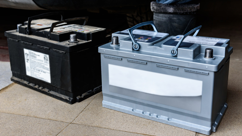 Two car batteries on the ground.