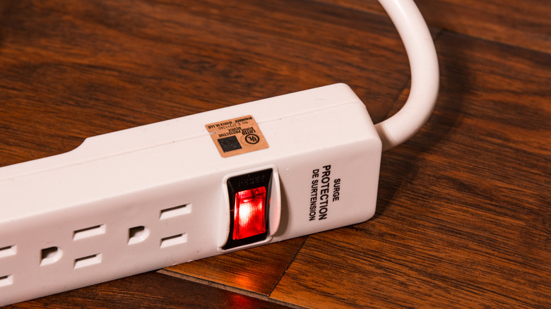 A white surge protector, turned on.