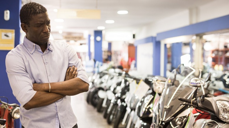 A person looking at a lineup of motorcycles at a motorcycle store