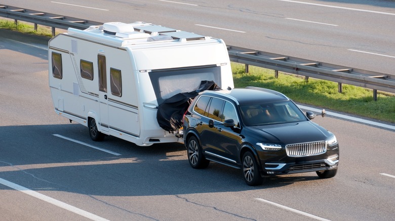 An SUV tows a home trailer on highway