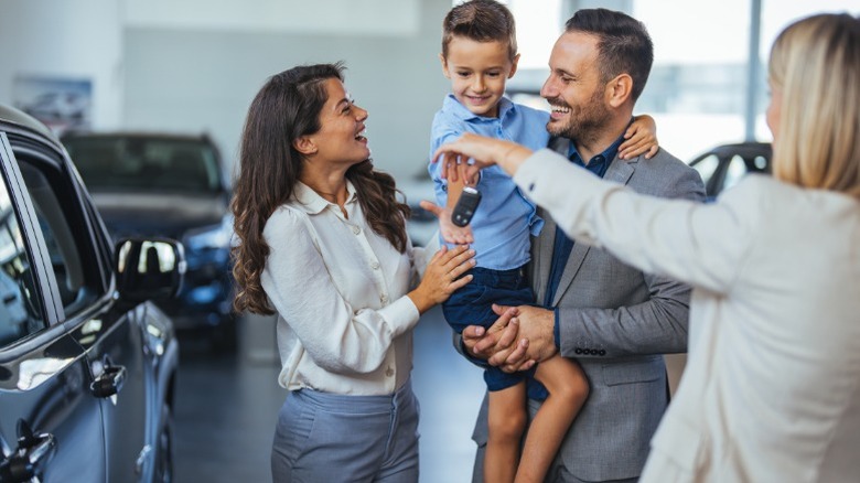 A family buying a new car at a dealership