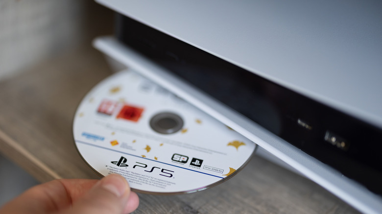 Shot of a PS5 disc being inserted into the console