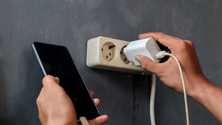 Plugging a phone into charging.