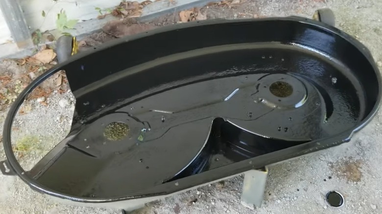 The underside of a lawn mower deck after coating with anti-rust paint