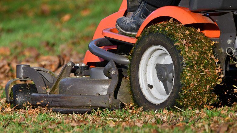 An orange mower mowing and mulching in the yard