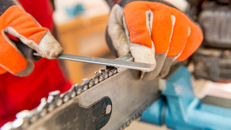 Close-up of chainsaw chain being sharpened.