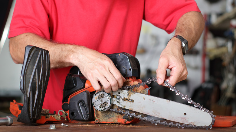A person cleaning their chainsaw.