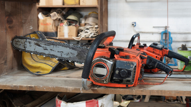 An old chainsaw stored on a shelf.