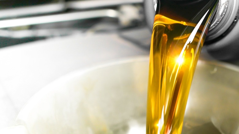A closeup image of someone pouring engine oil