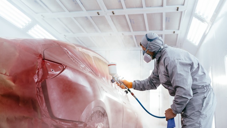 Technician performing a paint job on a car