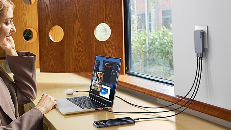 Woman using UGREEN slim-type phone charger for multiple devices