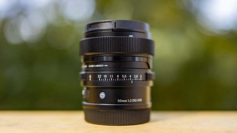 Sigma 50mm f2 lens on a wooden surface with a blurred out background.