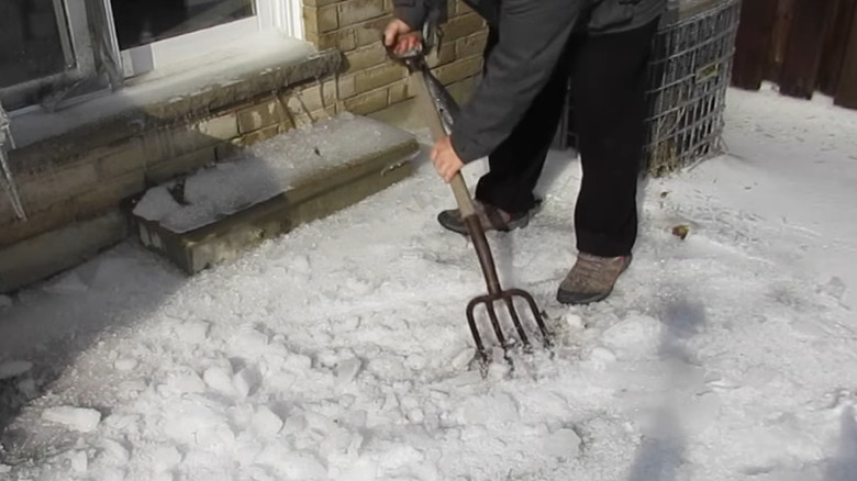 Pitchfork leaning against fence post