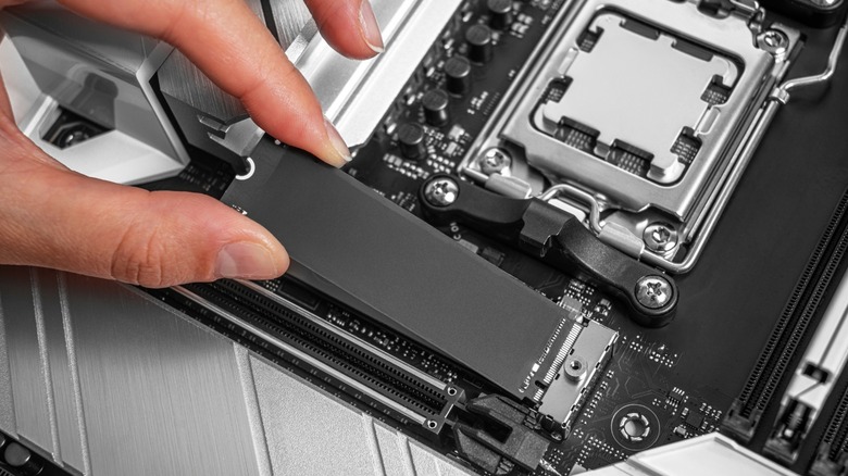 a person putting an SSD on a motherboard