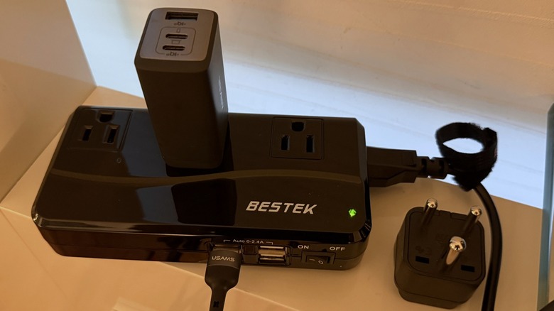BESTEK Universal Travel Adapter 100-220V to 110V Voltage Converter 250W with 6A 4-Port USB Charging 3 AC Sockets with Anker wall charger plugged in