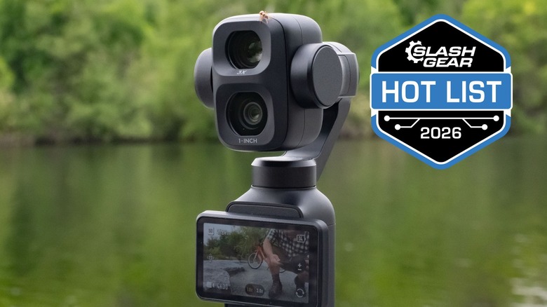 The DJI Osmo Pocket 4P camera with a lake and trees in the background.