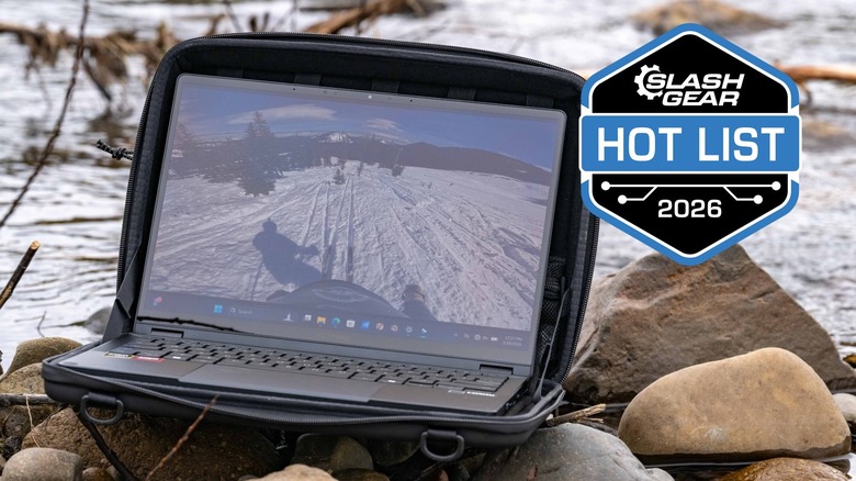 The Asus ProArt PX13 GoPro Edition laptop on rocks next to a river.