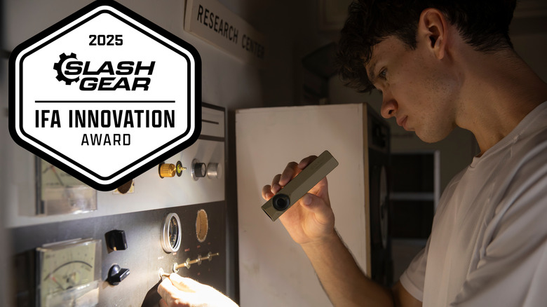 A man using an Olight ArkPro Ultra flashlight while inspecting an electrical panel