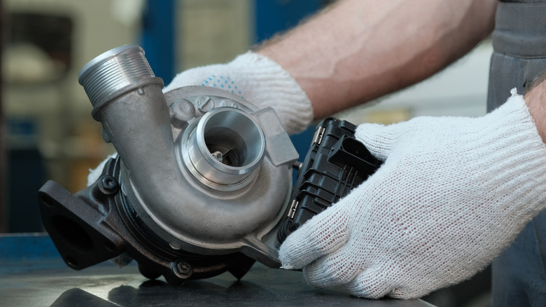 A metal turbocharger, being checked by an expert