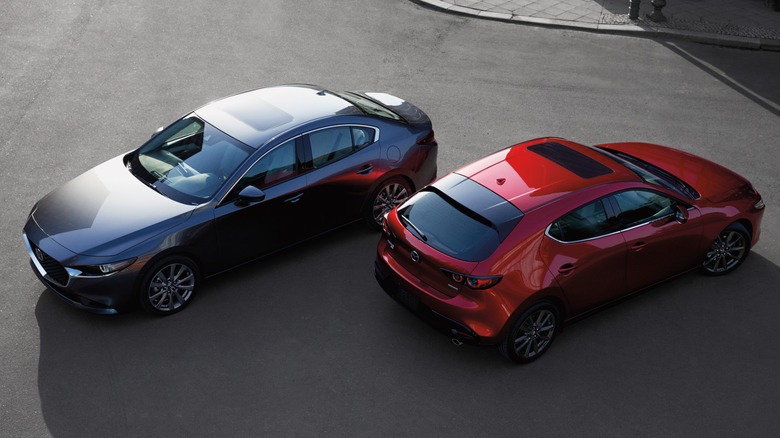 Blue and red 2026 Mazda3 sedan and hatchback parked outside