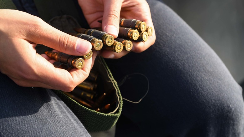 soldier holding 50. cal bullets