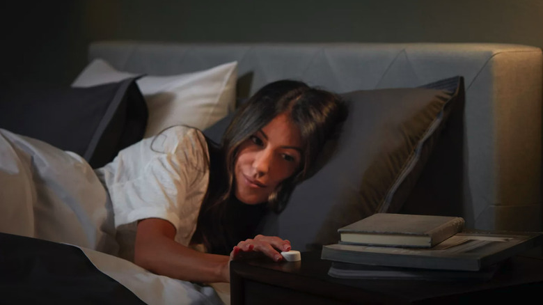 Woman in bed pressing smart button