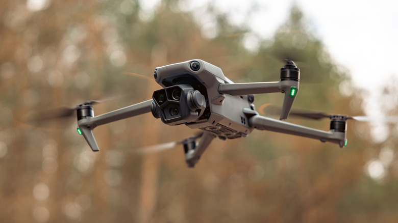 Close up of drone in the air with a forest in the background