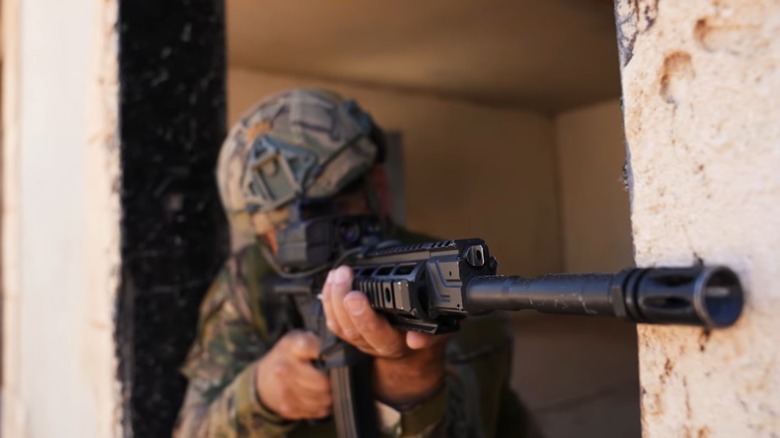 Soldier in a doorway aiming with a SMASH 2000L advanced scope
