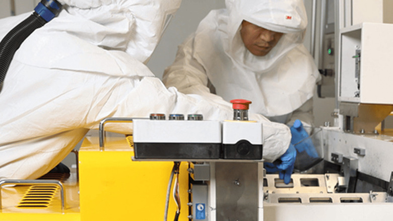 Factory workers in clean suits assembling Factorial solid state battery