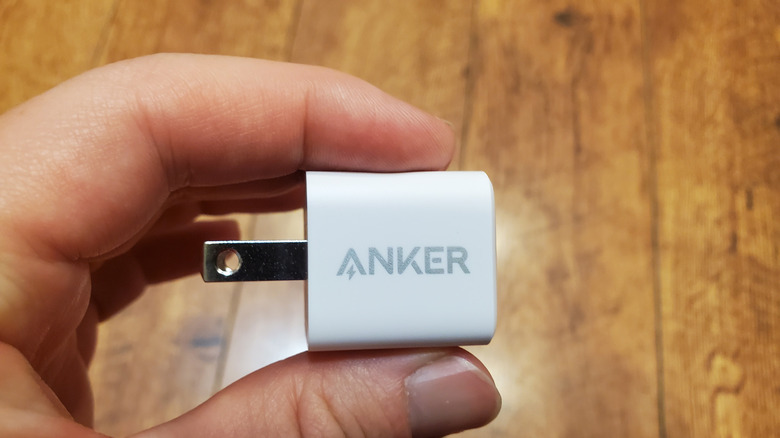 Close up of a hand holding an Anker plug charger