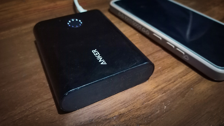 An Anker power bank shown alongside a phone on a table