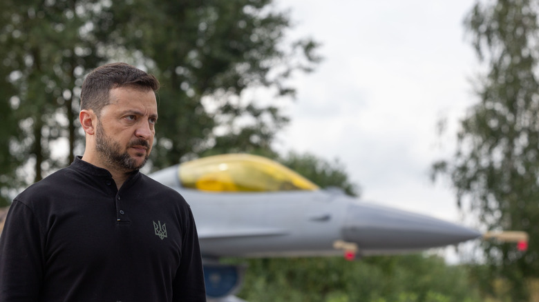 Ukrainian President Volodymyr Zelenskyy talks in front of Ukraine's Air Force's F-16 fighter jets in 2024.