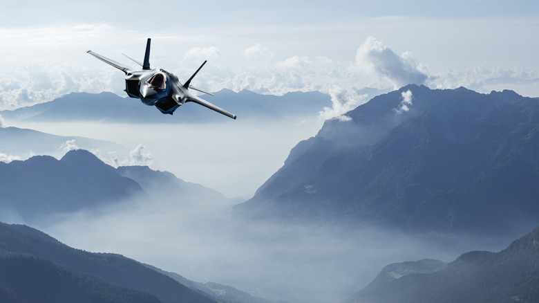 A F-35 stealth fighter jet soars over the Italian alps.