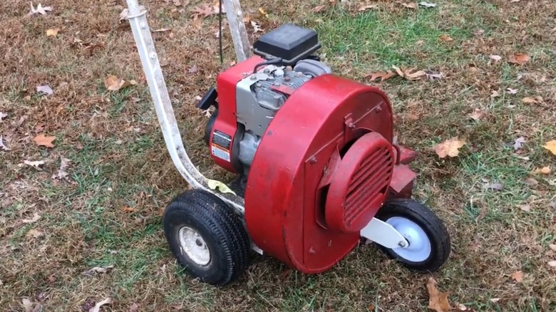 A vintage leaf blower in a yard.