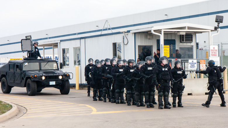 riot police with sonic weapon on truck