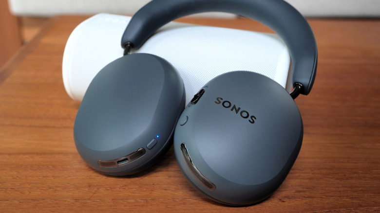Sonos Ace Ultra headphones resting on Sonos Play speaker