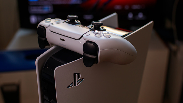 A PS5 controller resting on a PS5 console.