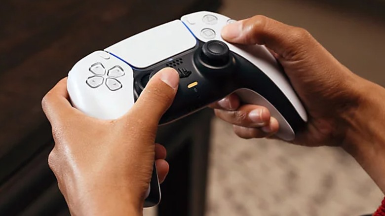 A person holding the PlayStation 5 DualSense controller