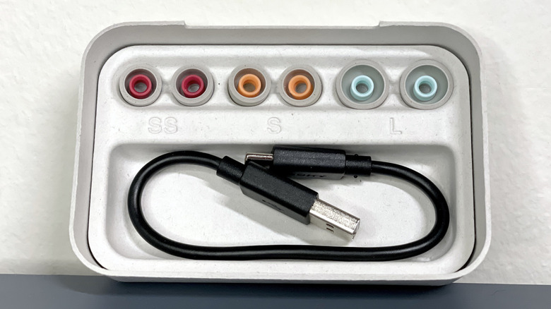 Inside of the WF-1000XM5 box with SS, S, and L tips as well as USB charging cable