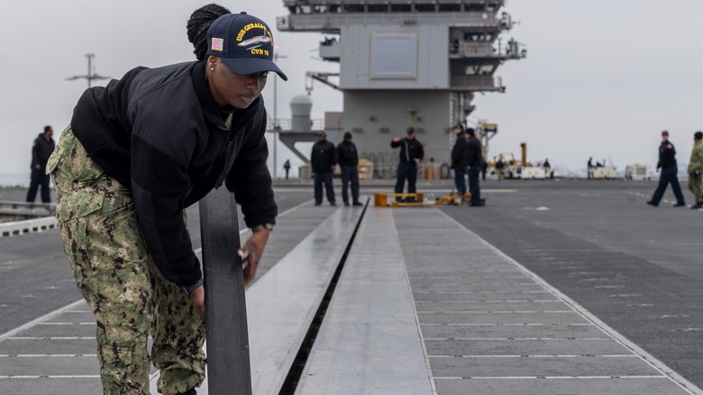 A sailor removing the covering on the USS Ford's EMALS