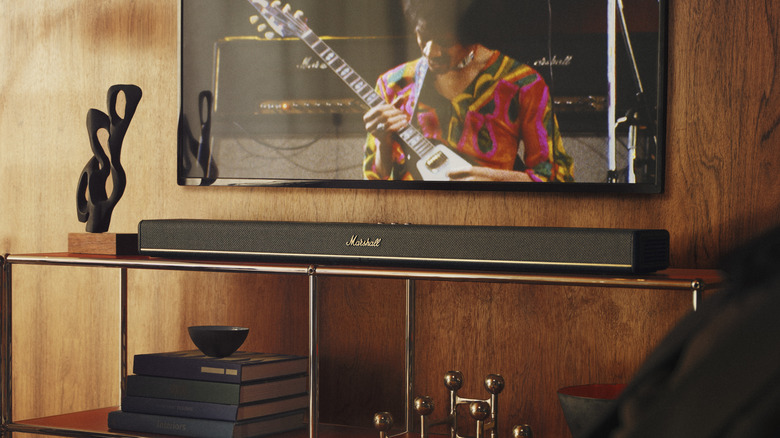 The Marshall Heston 120 soundbar under a television mounted on a wooden wall.