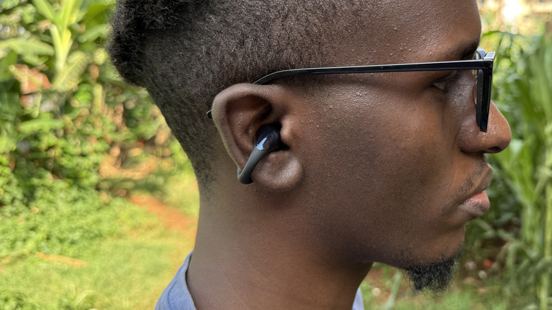 Man in glasses with clip-on earbuds on one ear