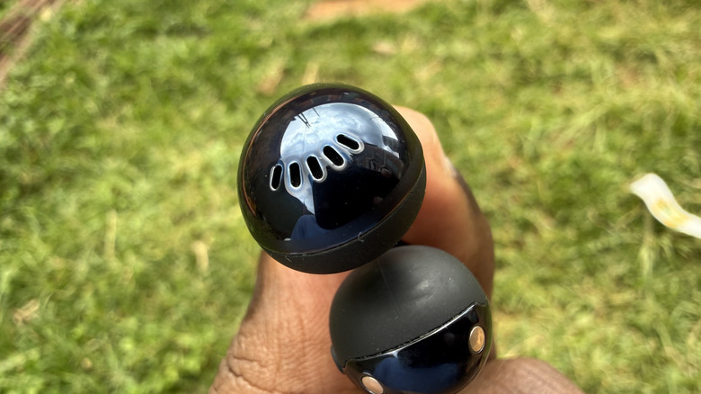 Person holding one piece of earbud